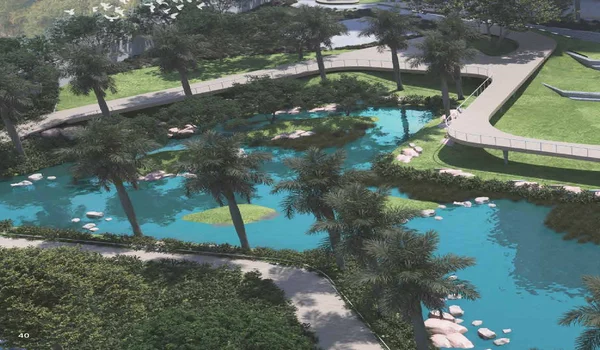 An aerial architectural rendering of the landscaped water feature at Sattva City apartments. The image shows a serene, bright blue lake winding through lush greenery and palm trees. A modern, elevated viewing deck with white lounge seating extends over the water, offering a peaceful outdoor common area for residents.